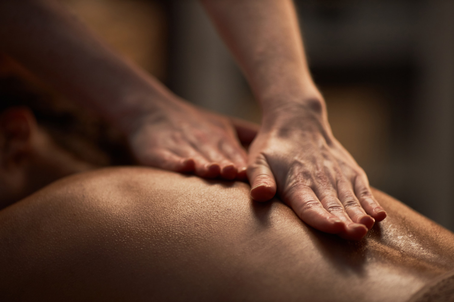 Hands,Of,Masseuse,Applying,Oil,On,Back,Of,Young,Woman